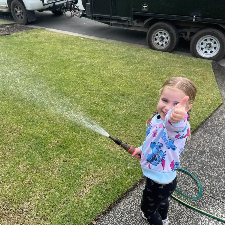 Thumbs up on a freshly mowed lawn — family-owned lawn mowing on the Northern Gold Coast